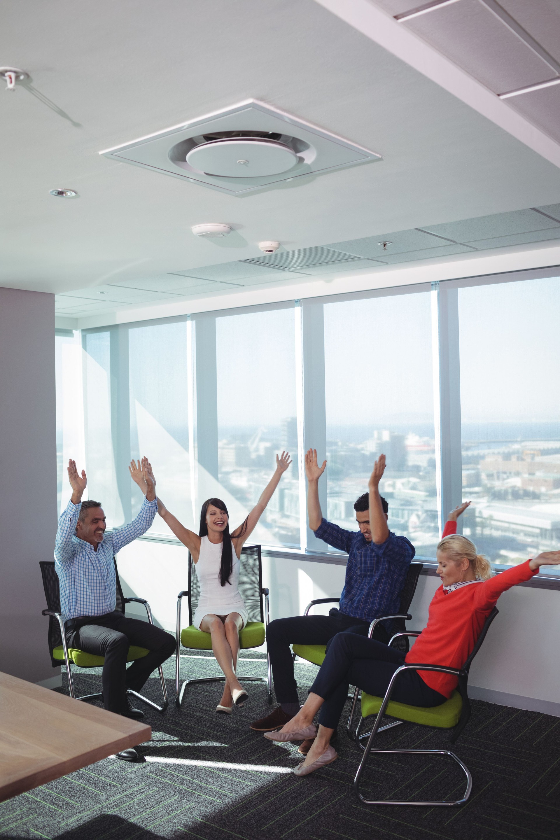Cheerful business people with arms raised at office