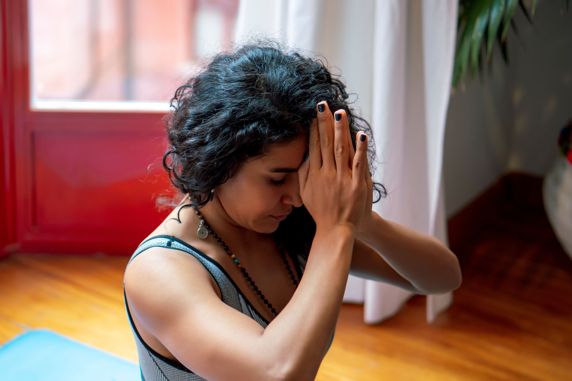 Latin woman performing hypopressive yoga exercises in her house